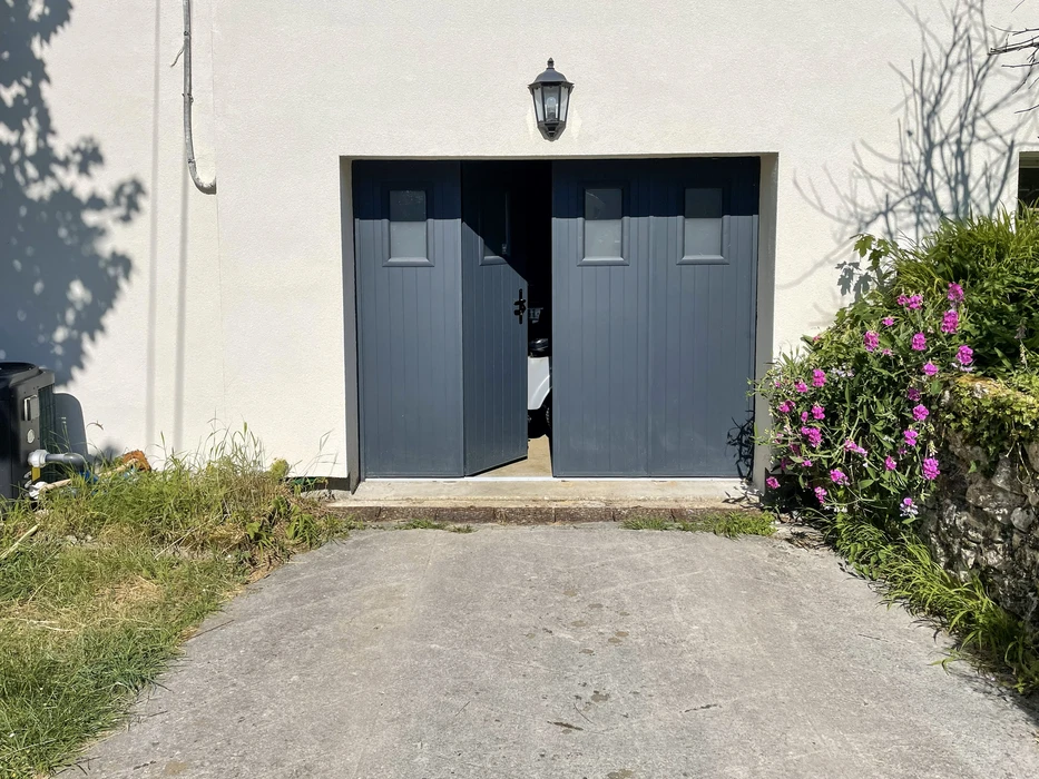 Portail résidentiel moderne en aluminium anthracite avec portillon intégré, installé entre piliers en béton