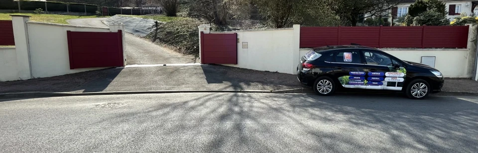 Scène extérieure résidentielle avec portail coulissant moderne en aluminium rouge bordeaux à lames horizontales